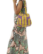 Modelo con el bolos de tela africana lila en el hombro.