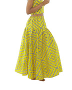 Falda larga de algodón en tela africana amarilla vista de perfil.