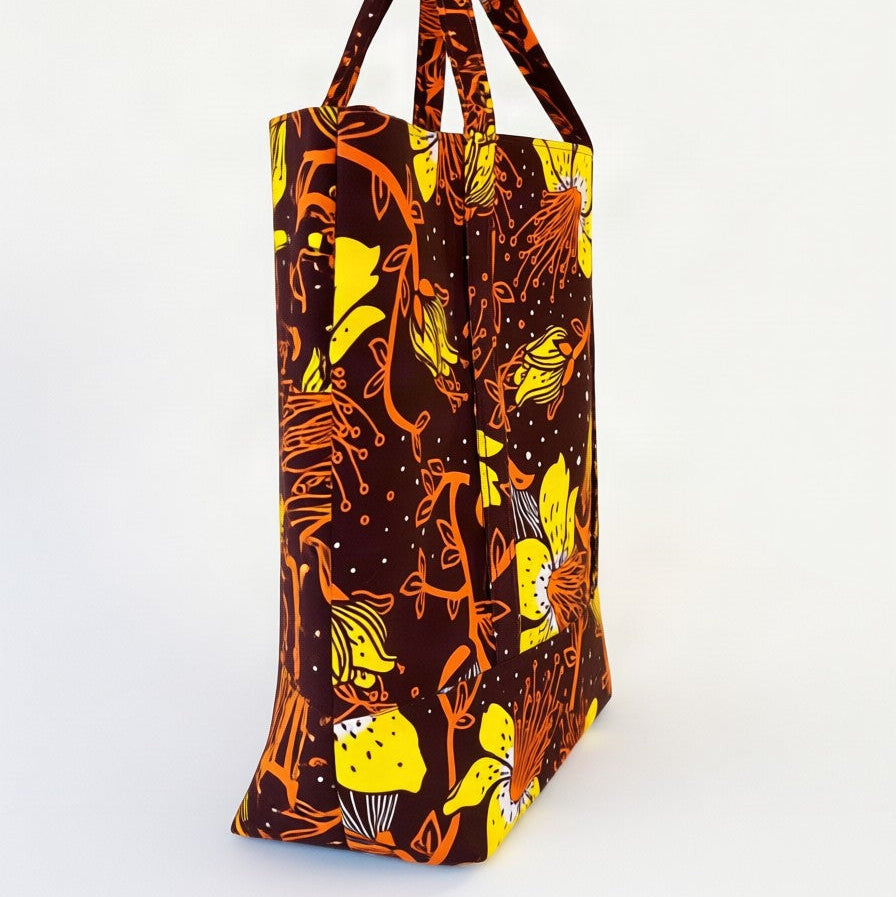 Vista de perfil del bolso tote nil de tela africana con un estampado floral marrón