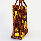 Vista de perfil del bolso tote nil de tela africana con un estampado floral marrón